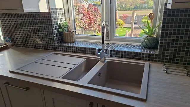 Kitchen sink and detailed mosaic-tiled window surround