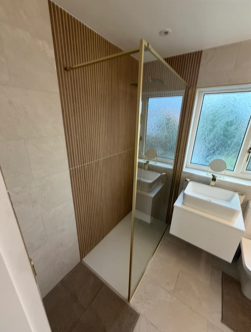 Gold-accented shower room by Baldwin's
